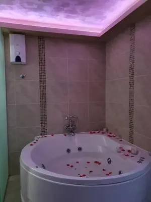 a bathroom with a tub with a pink ceiling at Leona apartment in Zemun