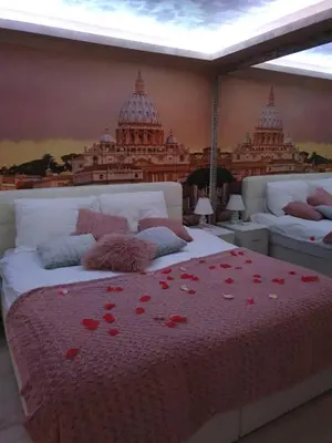 a bedroom with a bed with red flowers on it at Leona apartment in Zemun