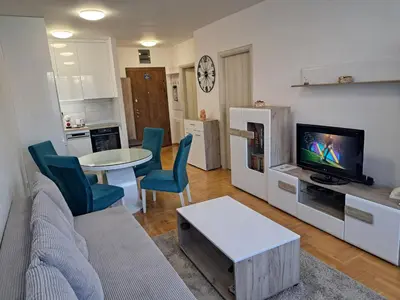 a living room with a couch and a table and a tv at Plavi Paun Apartman in Belgrade