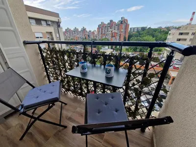 a balcony with a table and chairs on a balcony at Plavi Paun Apartman in Belgrade