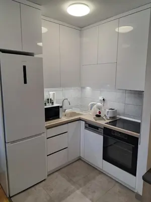 a white kitchen with white cabinets and appliances at Plavi Paun Apartman in Belgrade