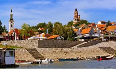 a town on the water with buildings and boats at Magistar in Zemun