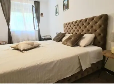 a bedroom with a large bed with a large headboard at Magistar in Zemun