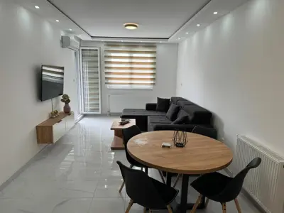 a living room with a couch and a table at Apartman Biser 5 in Ruma