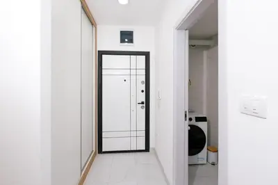 a hallway with a mirror and a white door at Apartman Biser 5 in Ruma