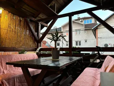 a wooden table with a potted plant on a patio at Icy Apartment in Belgrade