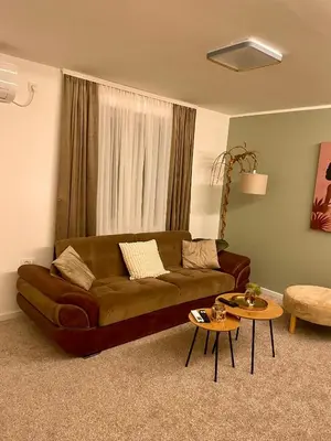 a living room with a brown couch and two tables at Osho in Smederevo