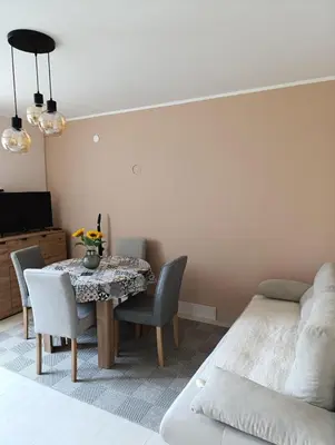 a bedroom with a table and chairs and a bed at Apartman Kokan in Obrenovac