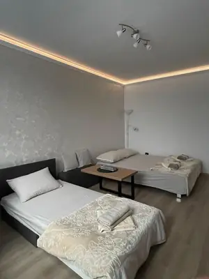 a room with two beds and a table in it at Apartman Silver Bg in Kneževac