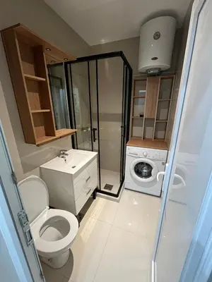 a bathroom with a toilet and a washing machine at Apartman Silver Bg in Kneževac