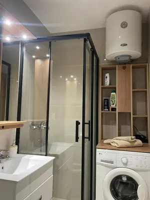 a bathroom with a shower and a washing machine at Apartman Silver Bg in Kneževac