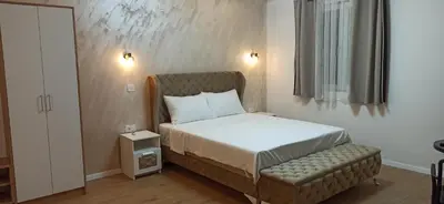 a small bedroom with a bed and a chair at Apartman Andjela in Surčin