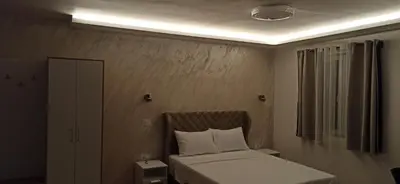 a small bedroom with a bed and a window at Apartman Andjela in Surčin