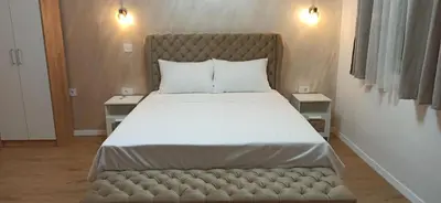 a bed with a tufted headboard in a bedroom at Apartman Andjela in Surčin