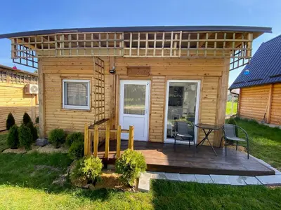 a small cabin with a deck with a table and chairs at Danube Oasis Stevantown 2 in Stari Banovci