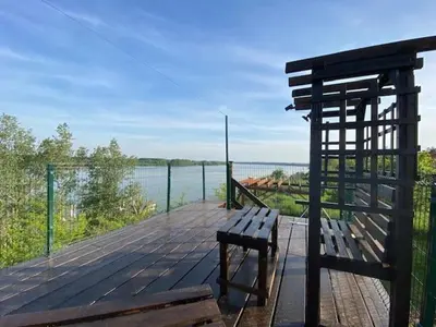 a wooden deck with a bench and a view of the water at Danube Oasis Stevantown 2 in Stari Banovci
