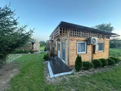a small wooden house in a grassy field at Danube Oasis Stevantown 2 in Stari Banovci