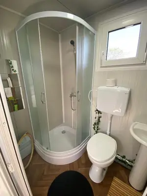 a bathroom with a shower and a toilet and a sink at Danube Oasis Stevantown 2 in Stari Banovci