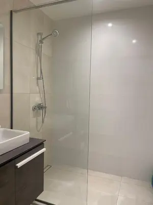 a glass shower in a bathroom with a sink at Belgrade Waterfront BW Sava Aqua in Sajmište