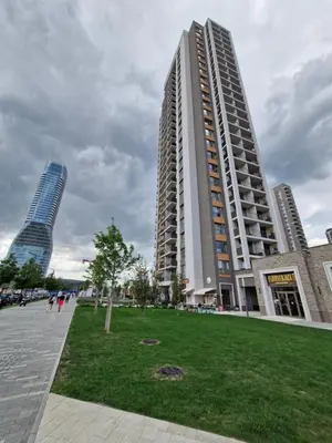 two tall buildings in a city with a park at Belgrade Waterfront BW Sava Aqua in Sajmište