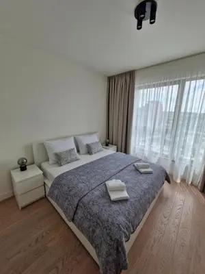 a bedroom with a large bed with two towels on it at Belgrade Waterfront BW Sava Aqua in Sajmište