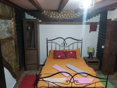 a bedroom with a bed with orange sheets and red pillows at Etno selo Smederevo PEPE- Serbia in Landol