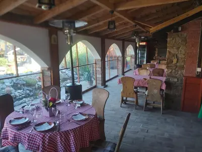 a dining room with tables and chairs and windows at Etno selo Smederevo PEPE- Serbia in Landol