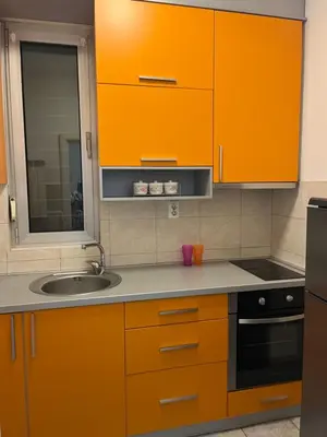 a kitchen with orange cabinets and a sink at Sofia in Belgrade
