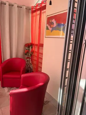 a living room with two red chairs and a painting at Sofia in Belgrade