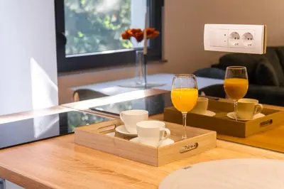 two glasses of orange juice and cups on a table at Uba Fruška gora in Velika Remeta