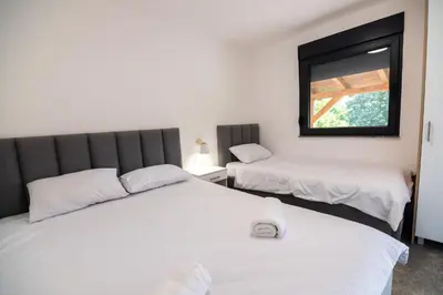 two beds in a room with a window at Uba Fruška gora in Velika Remeta