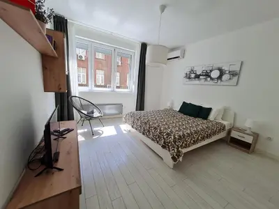 a bedroom with a bed and a chair in it at Jana - Cozy Apartment in the Old Town in Belgrade