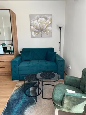 a living room with a blue couch and two chairs at View in Zvezdara