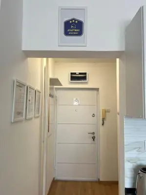 a hallway with a white door with a sign above it at View in Zvezdara