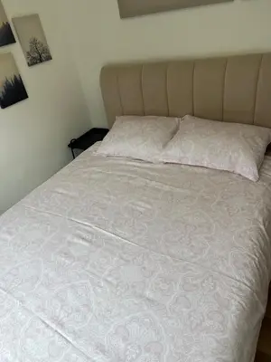 a bed with a white comforter and a pillow at Sanja, Old Town in Belgrade