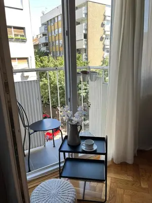 a room with a balcony with a table and a vase at Sanja, Old Town in Belgrade