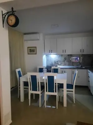 a dining room with a table and chairs and a kitchen at S Lux in Belgrade