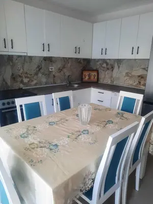 a kitchen with a table with blue chairs and white cabinets at S Lux in Belgrade