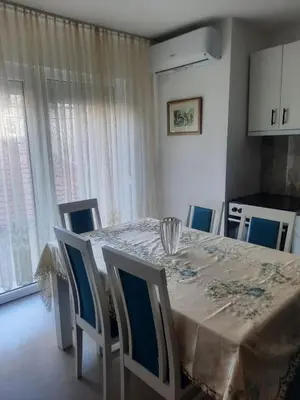 a dining room with a table and chairs and a kitchen at S Lux in Belgrade