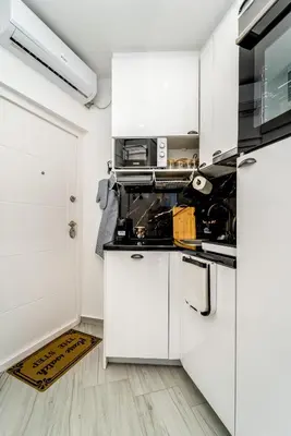 a kitchen with white cabinets and a microwave at New Urban Studio in Belgrade