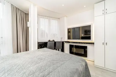 a bedroom with a bed and a tv and a desk at New Urban Studio in Belgrade