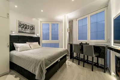 a bedroom with a bed and some windows at New Urban Studio in Belgrade