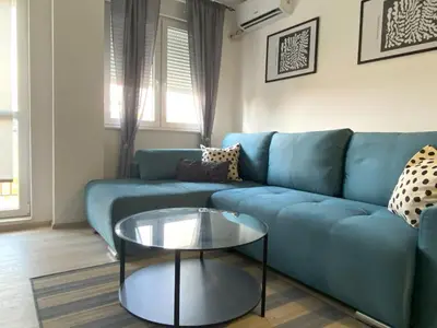 a living room with a blue couch and a table at Apartman Peric in Ruma