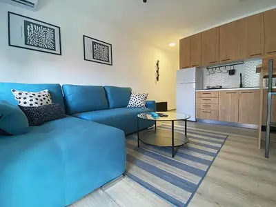a living room with a blue couch and a table at Apartman Peric in Ruma