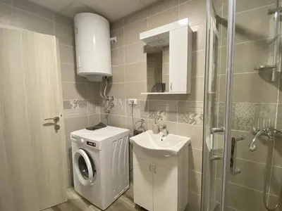 a bathroom with a washing machine and a sink at Apartman Peric in Ruma