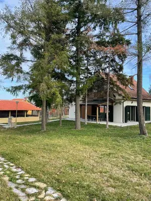 a house with trees in front of a yard at La Casa Sofija in Nemenikuće