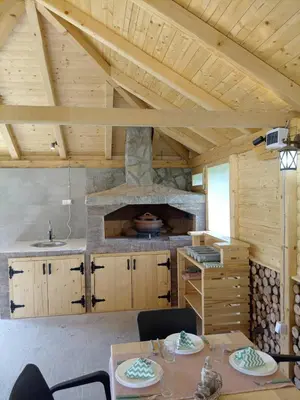 a kitchen with a table and a stone oven at La Casa Sofija in Nemenikuće