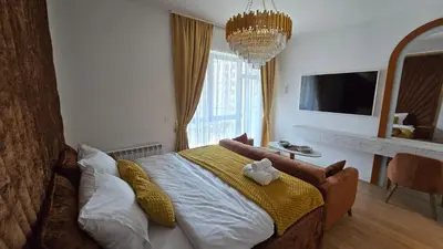 a bedroom with a large bed with a yellow blanket at Beldorado Apartments - Belgrade Waterfront Luxury Designer Studio in Belgrade