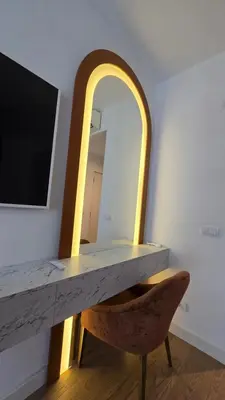 a table and a chair in a room with a mirror at Beldorado Apartments - Belgrade Waterfront Luxury Designer Studio in Belgrade