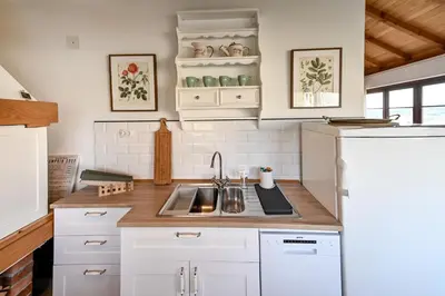 a kitchen with white cabinets and a sink at Smart glamp in Bukovik